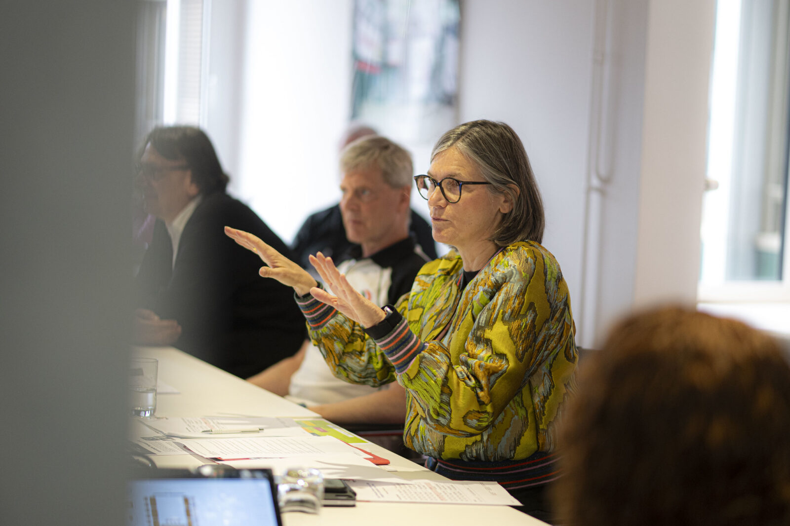 Close-up of IndustriALL president Christiane Benner speaking with hands raised during a meeting at IndustriALL Global Union offices, Geneva, 25 March 2026