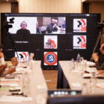 Online participants join the IndustriALL Pakistan affiliates meeting via video call, displayed on a large screen in the conference room