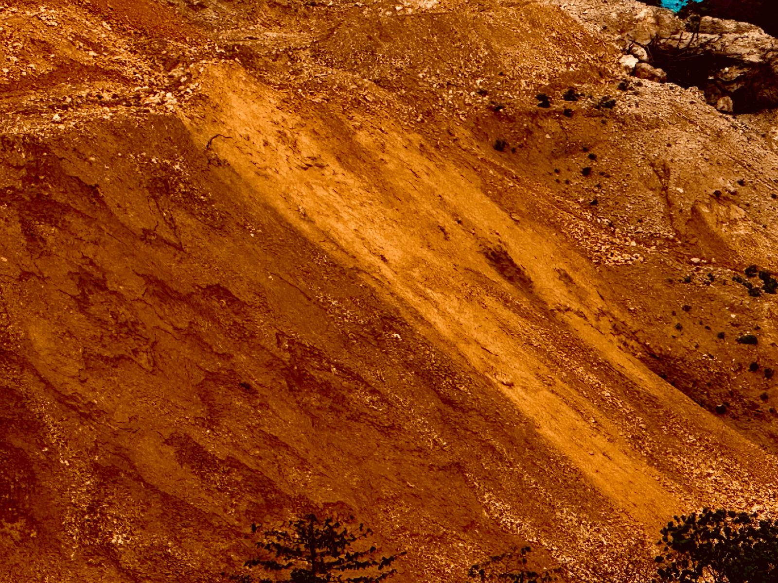 Steep orange-red mine heap at an open-pit mine in Indonesia