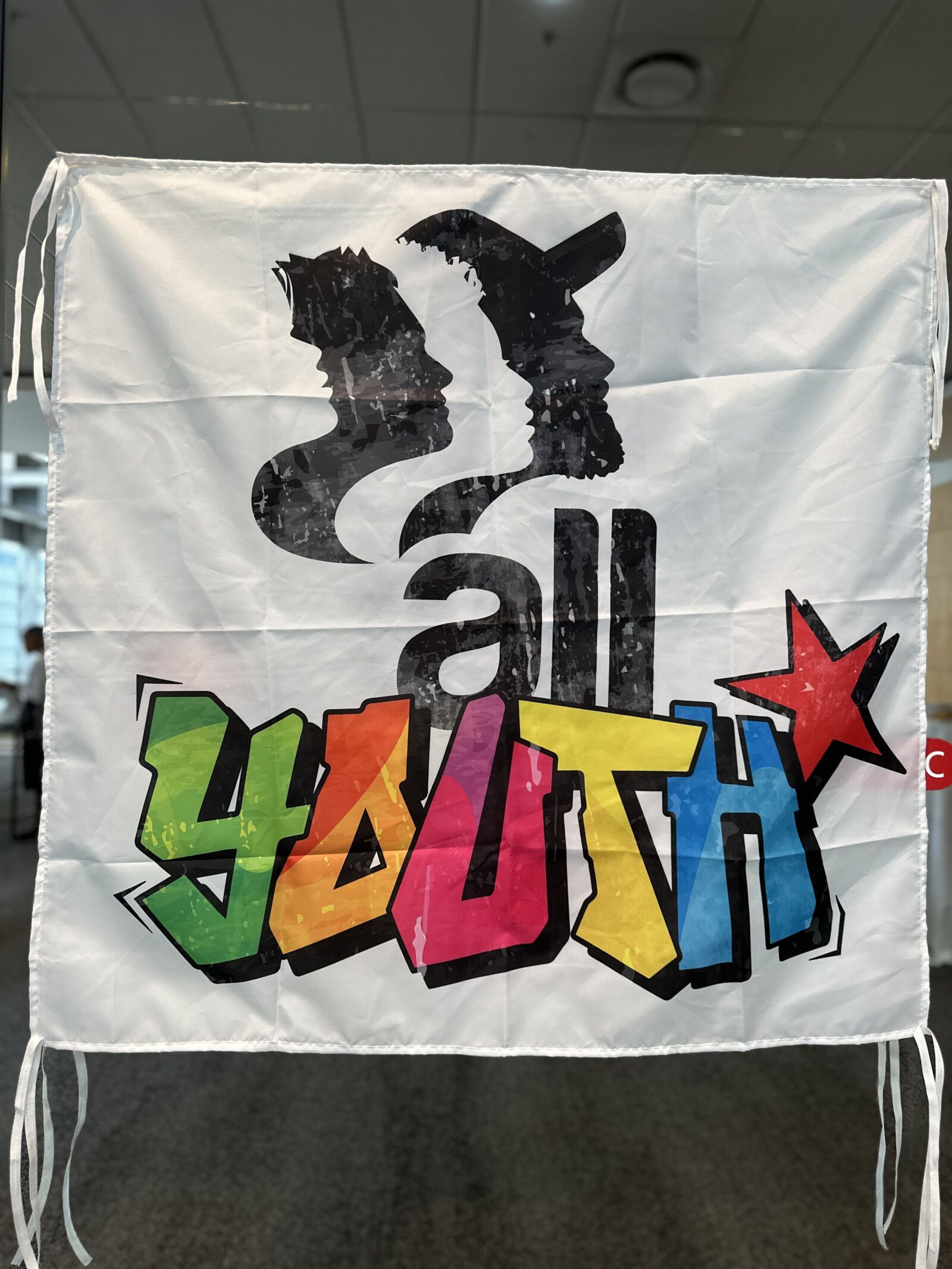 IndustriALL Global Union youth banner displaying the words "all youth" in colourful graffiti-style lettering with a red star, displayed at a youth conference in Cape Town, June 2023.