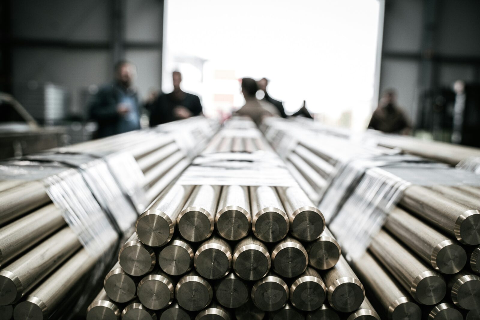 Barras cilíndricas de metal apiladas en una planta industrial del sector de metales básicos