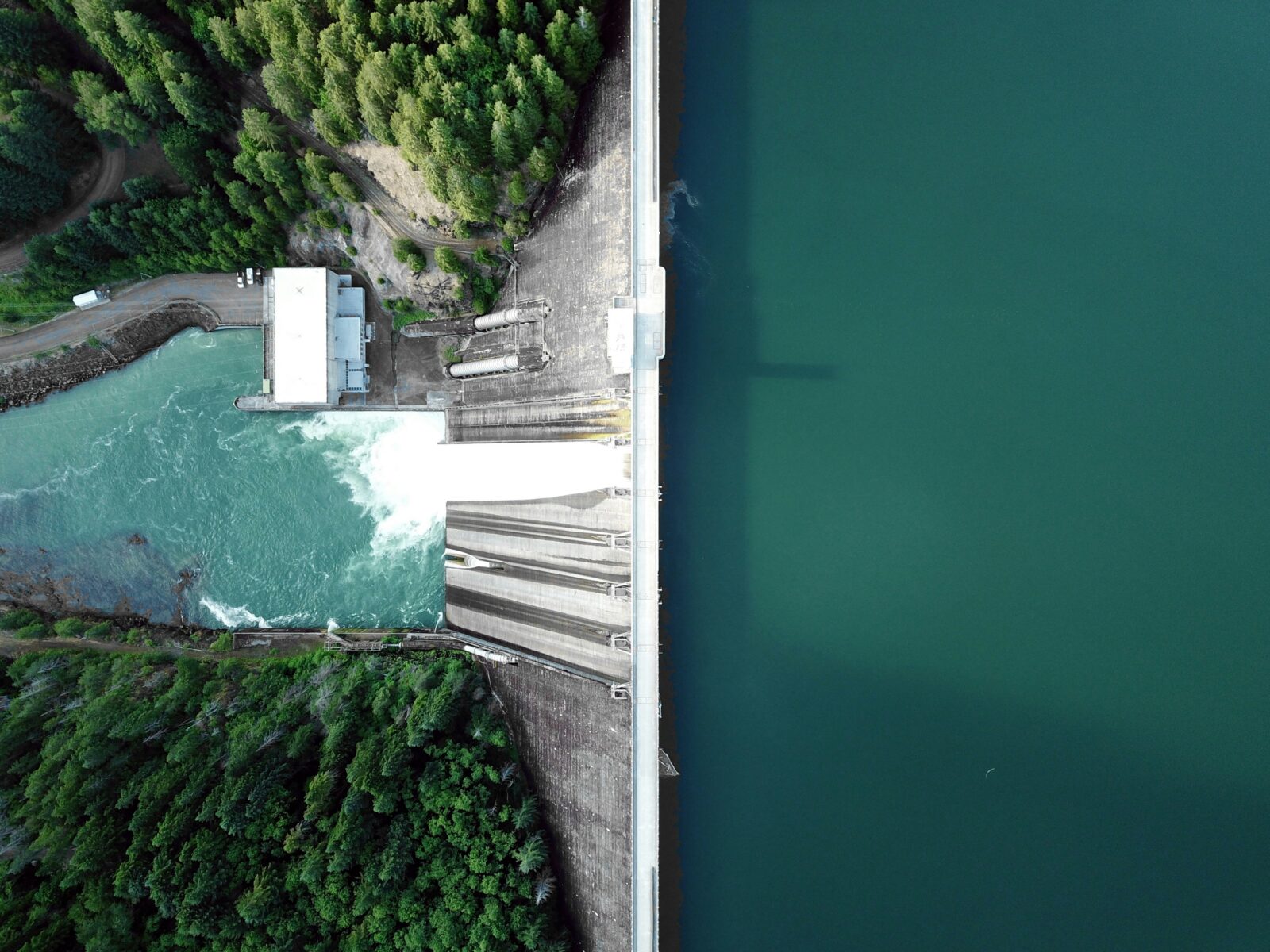 Vista aérea de una represa hidroeléctrica rodeada de bosque y agua