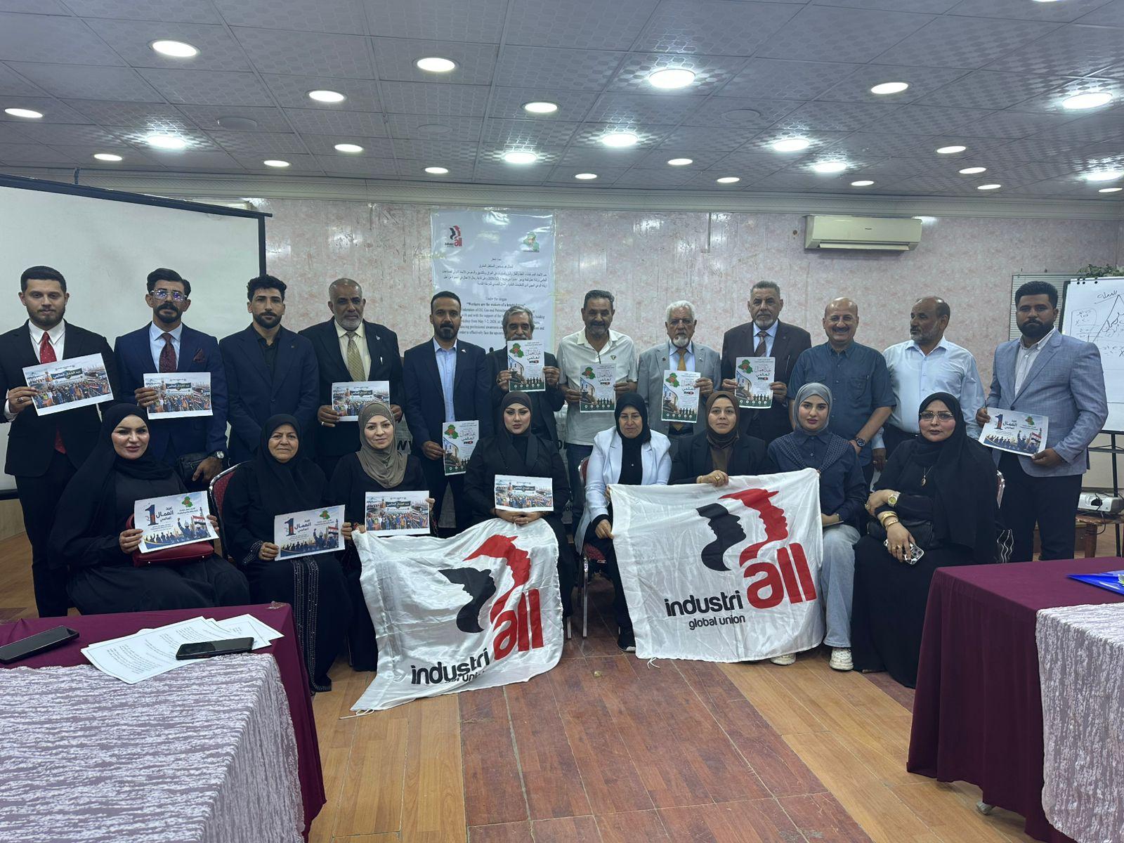 rade unionists pose for a group photo holding IndustriALL Global Union flags and printed materials at a workshop in Basra, Iraq