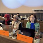 Delegates from Indonesia and Japan follow proceedings at the IndustriALL women's committee meeting.
