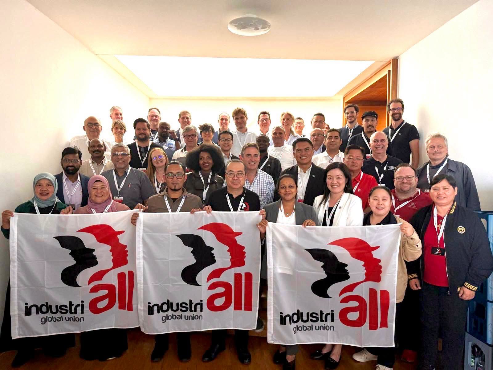 Delegates at IndustriALL's joint conference on the future of work pose with IndustriALL Global Union flags in Berlin