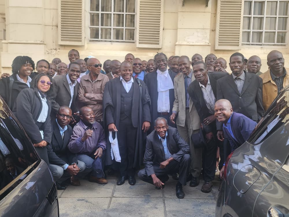 Waverley Blankets workers celebrate with their lawyers outside the Supreme Court in Harare, Zimbabwe.