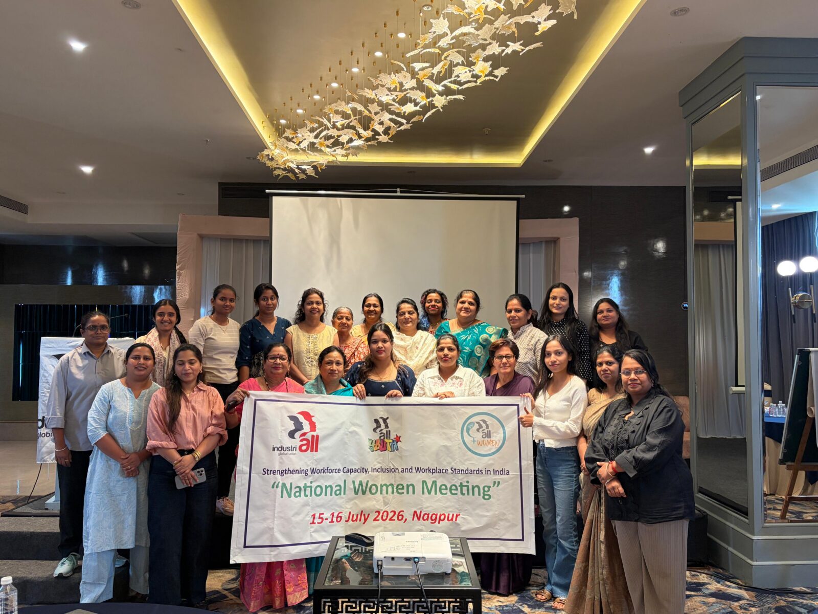Women delegates at IndustriALL National Women's Meeting in Nagpur holding banner reading "Strengthening Workforce Capacity, Inclusion and Workplace Standards in India