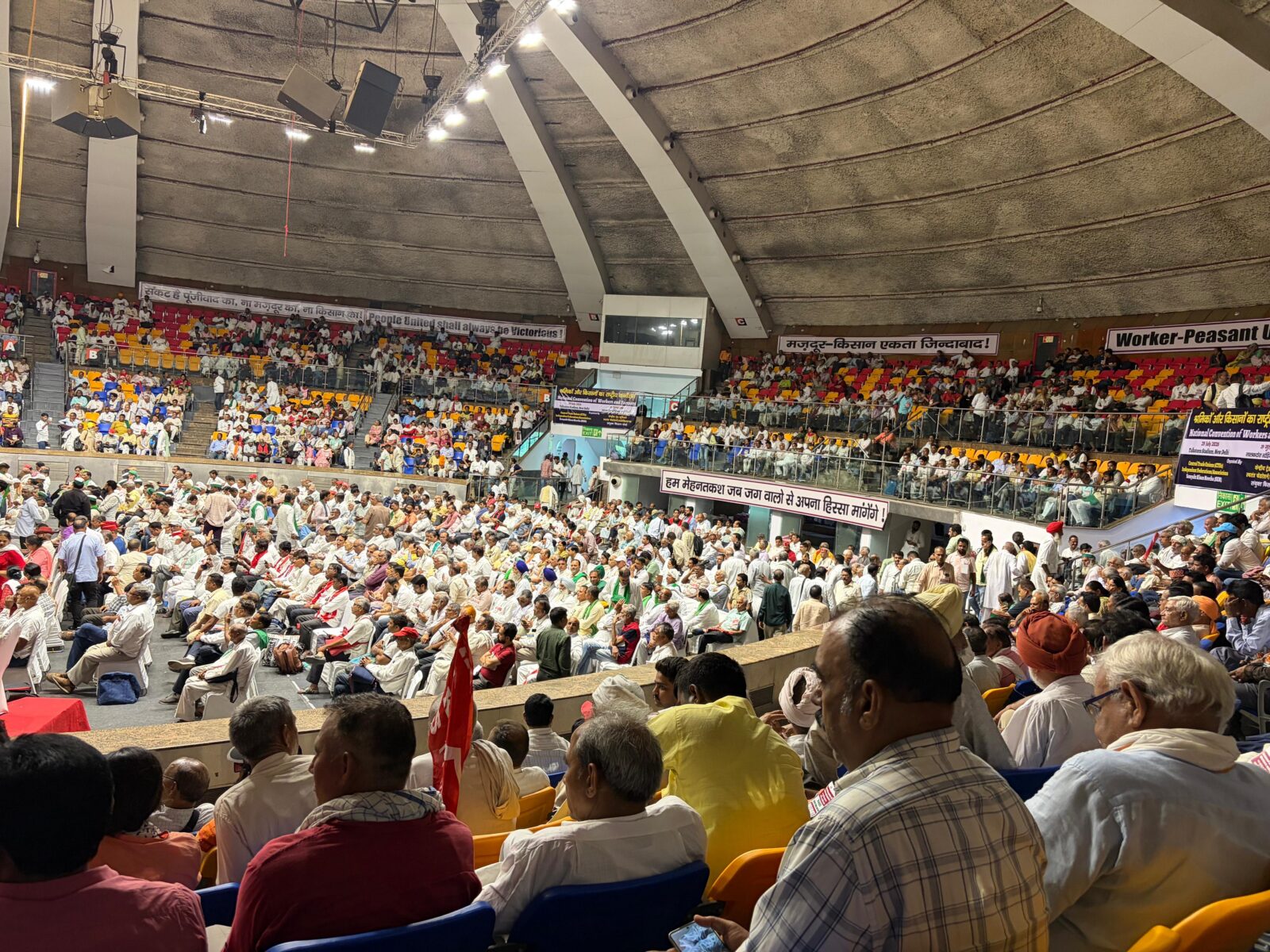 Crowd of trade union and farmer delegates seated in a domed stadium in New Delhi at the joint convention of workers and farmers, India, July 2026.