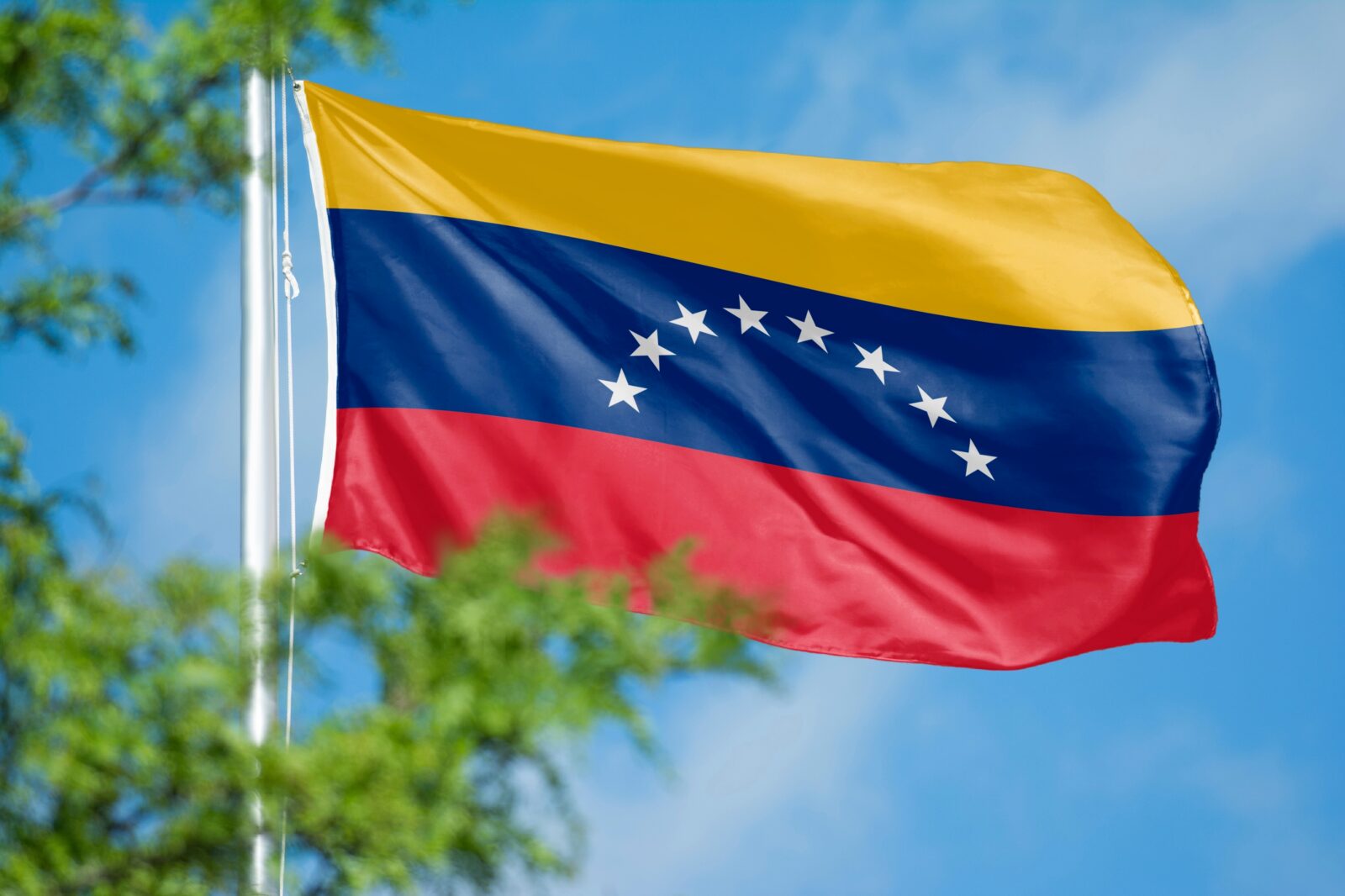 Venezuelan flag flying against a blue sky