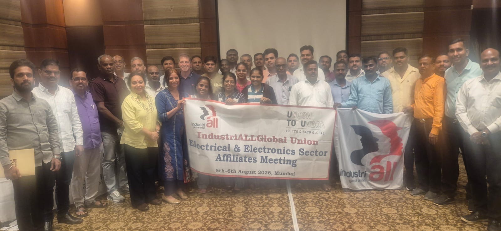 Trade union representatives from India's electrical and electronics sectors gather indoors holding IndustriALL banners at the strategic organizing workshop in Mumbai on 5-6 August 2026.
