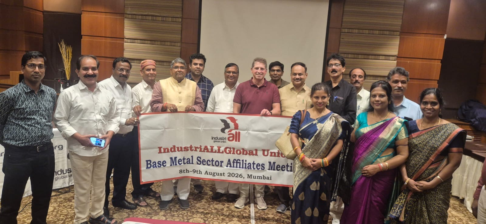 Trade union leaders from India's base metal sector hold an IndustriALL banner at an indoor meeting in Mumbai on 8-9 August 2026.