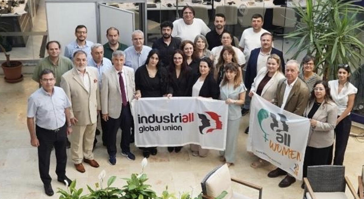 Approximately 30 Turkish union leaders and women activists stand together in an Istanbul office, holding IndustriALL global union and Turkish Women's Network banners at a gender equality meeting.