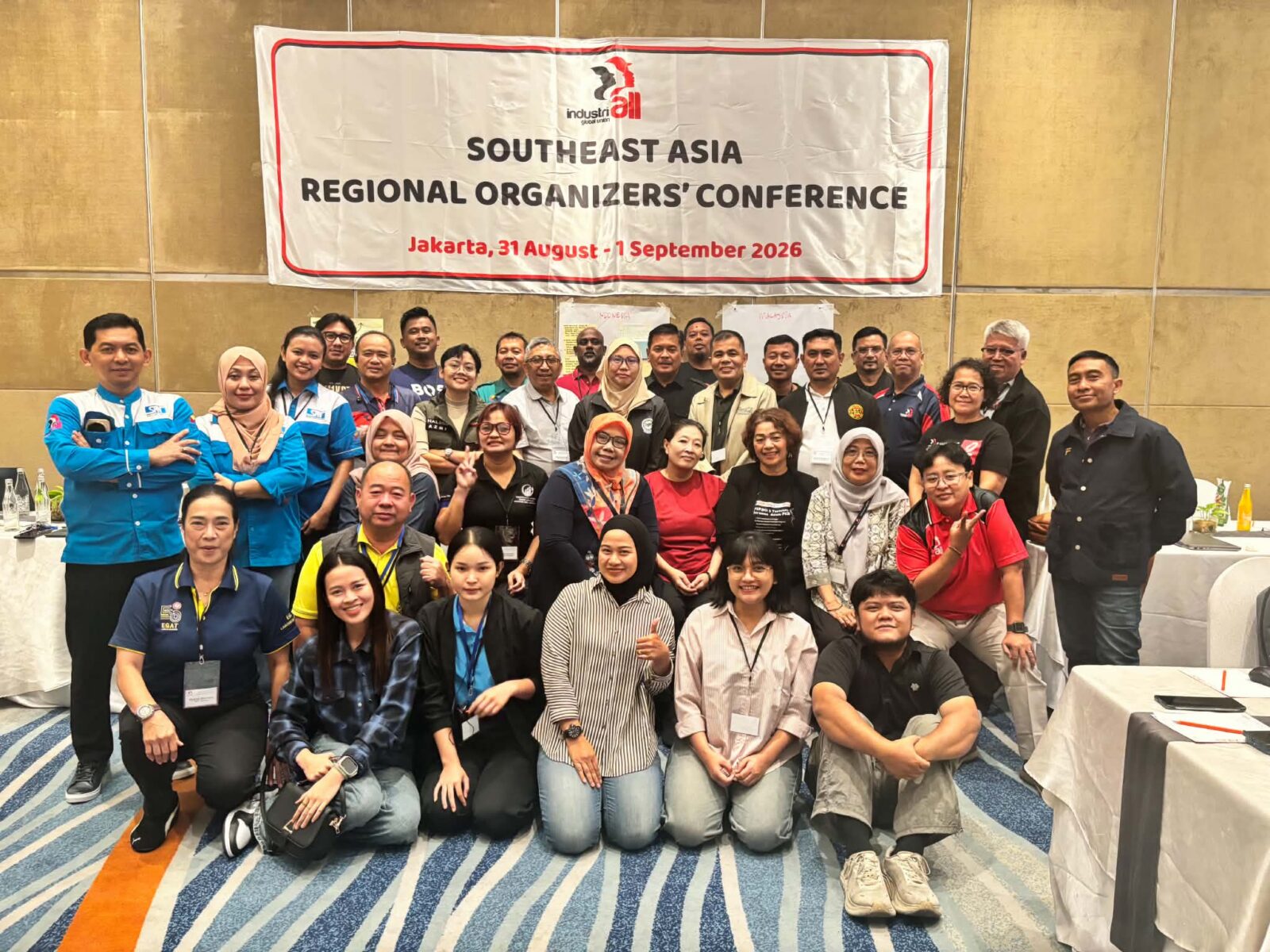Group photo of trade union organizers at the Southeast Asia Regional Organizers' Conference in Jakarta, standing and kneeling in front of an IndustriALL banner.