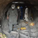 Pakistan miners walking through a brick-arched mine tunnel. Image: Mazhar Chandio/Anadolu/picture alliance