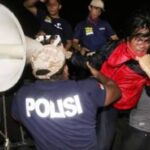 Полицейские избивают участника акции.