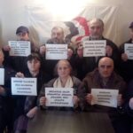 Des mineurs géorgiens tiennent des pancartes portant leurs revendications au gouvernement et à l’entreprise.