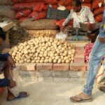 Рабочий-поденщик подсчитывает копейки, чтобы купить овощи, потому что он не смог обменять старые банкноты на новые.