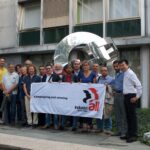 Les représentants syndicaux de STMicroelectronics devant la sculpture dédiée à la Solidarité internationale au siège d'IndustriALL à Genève