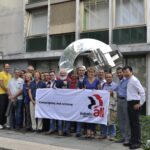 Les représentants syndicaux de STMicroelectronics devant la sculpture dédiée à la Solidarité internationale au siège d'IndustriALL à Genève