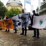 Участники акции протеста, организованной около места проведения ежегодного собрания акционеров BHP Billiton, воспроизводят события аварии на шахте Samarco. Фото: War on Want