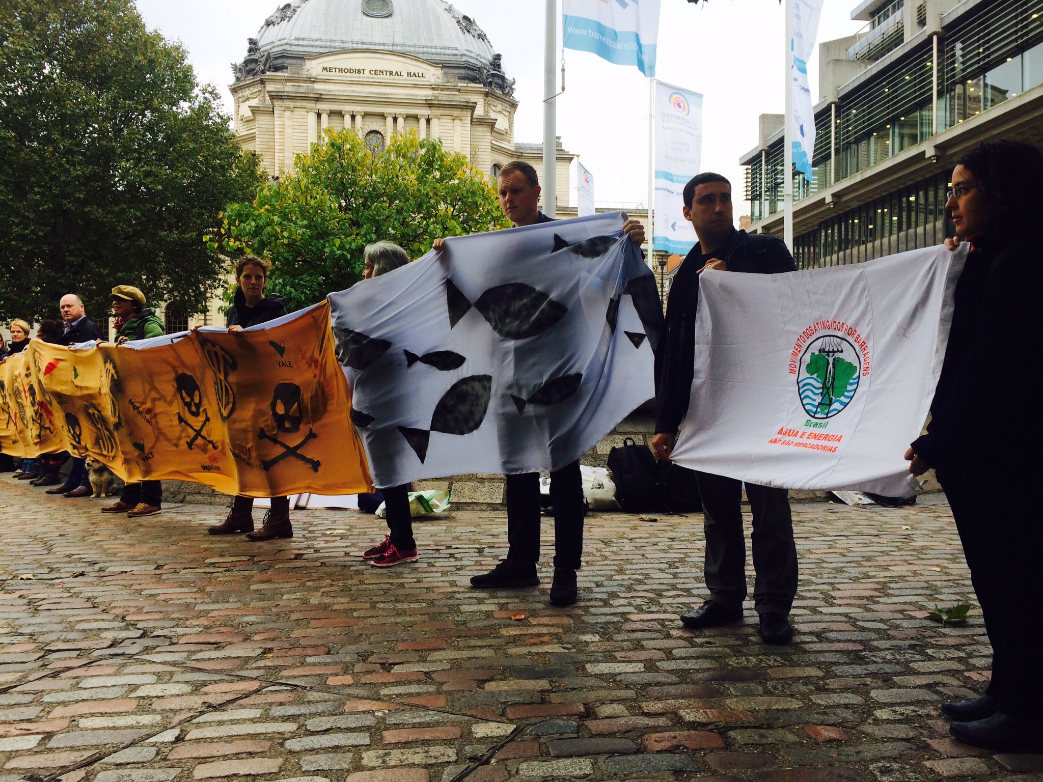 Участники акции протеста, организованной около места проведения ежегодного собрания акционеров BHP Billiton, воспроизводят события аварии на шахте Samarco. Фото: War on Want