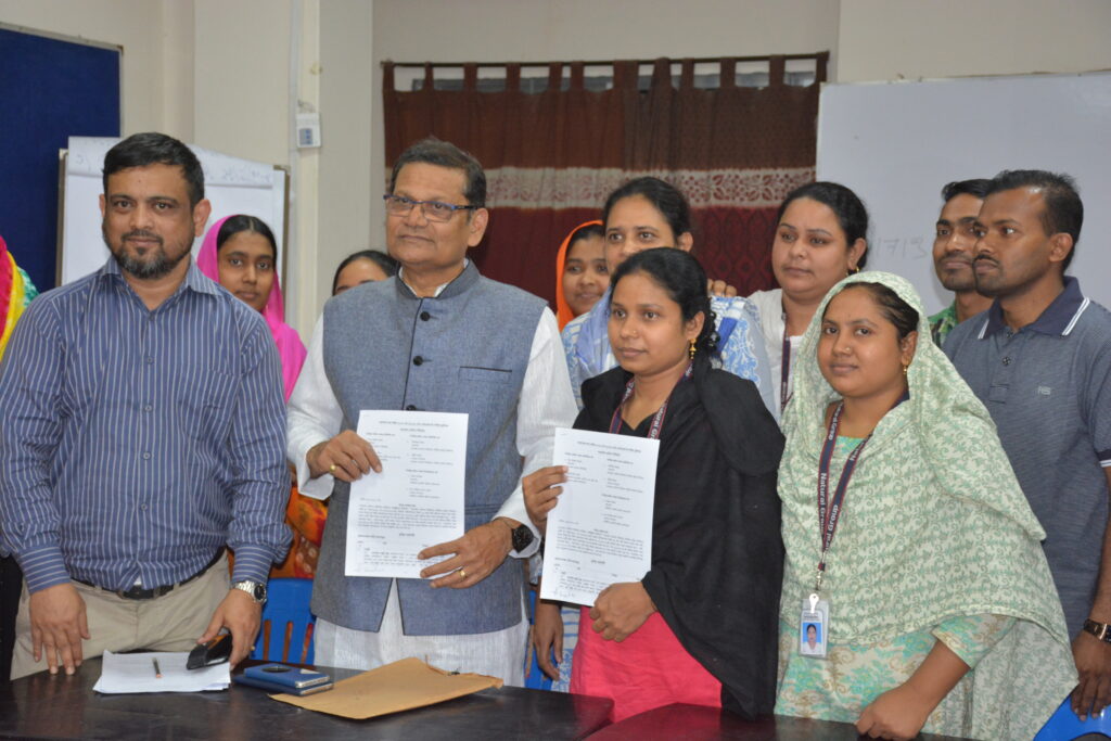 Bilkis Akhter and Shilpi Akhter sign the agreement on behalf of the union