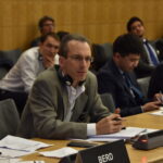 Директор отраслевого сектора цветной металлургии Адам Ли выступает на заседании ОЭСР.