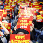 Члены профсоюза KMWU держат плакаты с призывом: “Принять законопроект о реформе чеболей и специальный закон о развитии производственной базы”, скандируя лозунги о реформе чеболей. Фото: Шин Дон Джун