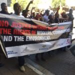 Protests march behind the IndustriALL banner. 