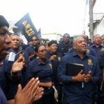 Рабочие собрались около здания Министерства труда в Тринидаде в ожидании подписания соглашения о повышении заработной платы. Фото: OWTU