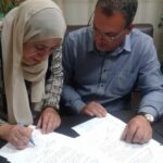 Министр социального обеспечения (слева) подписывает соглашение с лидером профсоюза Тахаром Бербери.