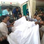 Раненного рабочего увозит карета “скорой помощи”.