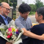 ФОТО Хан Сан Гюн, бывший президент Корейской конфедерации профсоюзов, и Чо Чан Ик, президент Корейского профсоюза учителей и работников образования, встречают сестру Ли Юн Чжу около Центра заключения Сеула, фото со страницы KCTU в Facebook