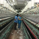 Industrial looms are operated at a rug factory. © ILO