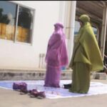 Работники молятся за пределами здания